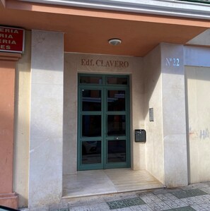 A building entrance with a green door labeled 'Edf. CLAVERO' and a sign 'Nº22' on the right. - Apartment in Nerja Near Sandy Beach (Nerja)
