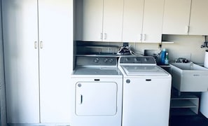 A compact kitchen with a washing machine, a stove, and a sink. - Private Heated Pool-Near Naples Beaches-2BR/2BA (Naples)