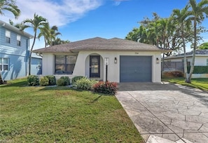 A single-story house with a garage, a front lawn, and a driveway. - Private Heated Pool-Near Naples Beaches-2BR/2BA (Naples)