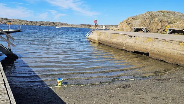 A pier extending into calm water with a rocky shoreline in the background. - Charming cottage by the sea in Stocken | SE09171 (Ellös)