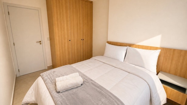 Ein Schlafzimmer mit einem Bett, einem Kleiderschrank und einem Nachttisch.