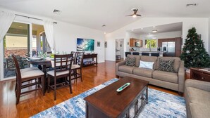 A spacious living room with a dining area, a kitchen in the background, and a Christmas tree. - Newly Remodeled Home in Waikoloa Village!  WeloWelo House (Waikoloa Village)