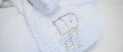 A close-up of a white fabric with a gold embroidered design.