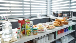 Una cocina con barra de desayuno, diversos alimentos y electrodomésticos.