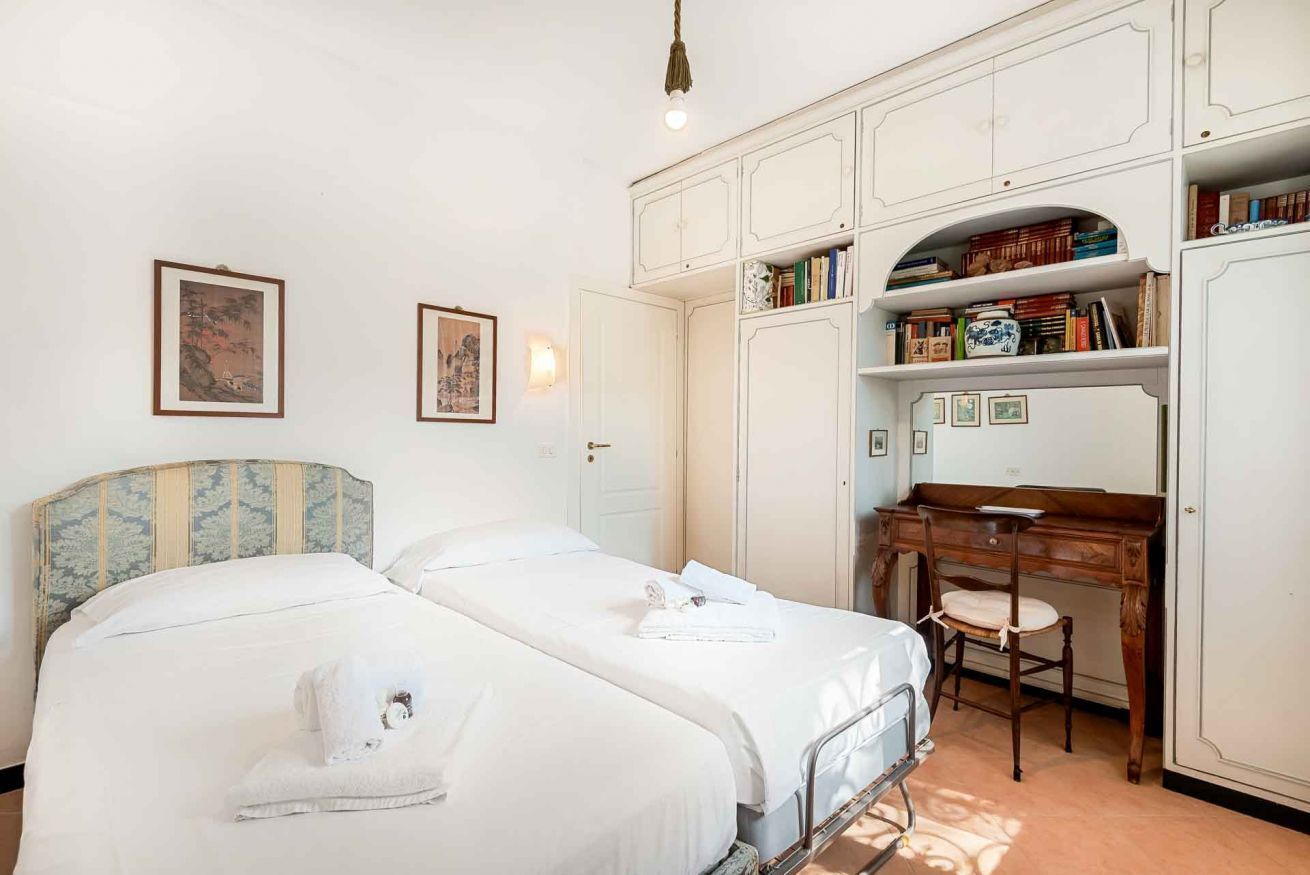 Una camera da letto con due letti, una scrivania e un armadio.