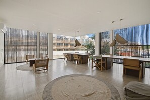 Une pièce spacieuse avec une grande table à manger, des chaises en bois et un tapis rond.