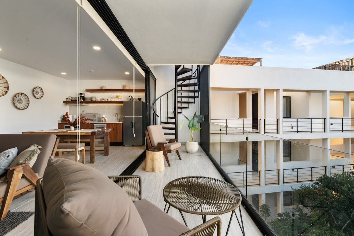 A modern apartment with a balcony, a kitchen, and a dining area.