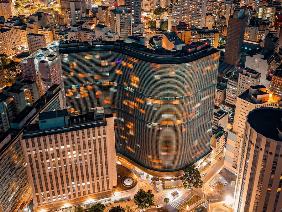 A high-rise building with a curved facade, surrounded by other tall buildings in an urban setting.