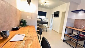 Een moderne keuken met een houten eettafel, stoelen en een inbouwfornuis.