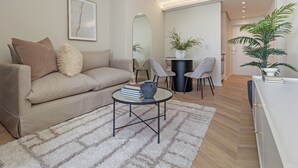 Un salon moderne avec un canapé, une table basse et une plante en pot.