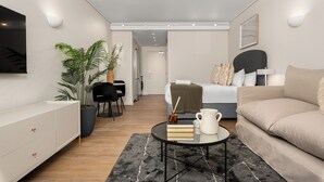 Une pièce moderne et bien éclairée, avec un canapé, une table basse, un téléviseur et une plante en pot.