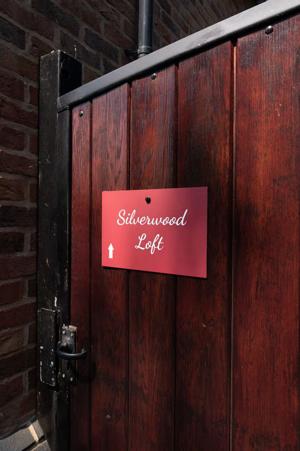 Un letrero rojo sobre una puerta de madera que indica el Silverwood Loft.