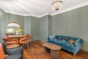 A room with a dining table, chairs, a sofa, and a mirror. - Bohemian Living in the Heart of Marylebone - Pass the Keys (London)
