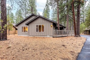 A cabin with a wooden exterior, large windows, and a deck. - Sunriver 4 BDRM, Hot Tub, AC, Dog Friendly - TOPF16 (Sunriver)