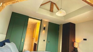 A bedroom with a sloped ceiling, a bed, a desk, and a chair. - Rembrandt - luxury authentic room at Museumplein (Amsterdam)