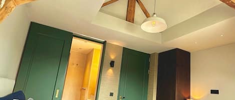 Un dormitorio con techo inclinado, una cama, un escritorio y una silla.