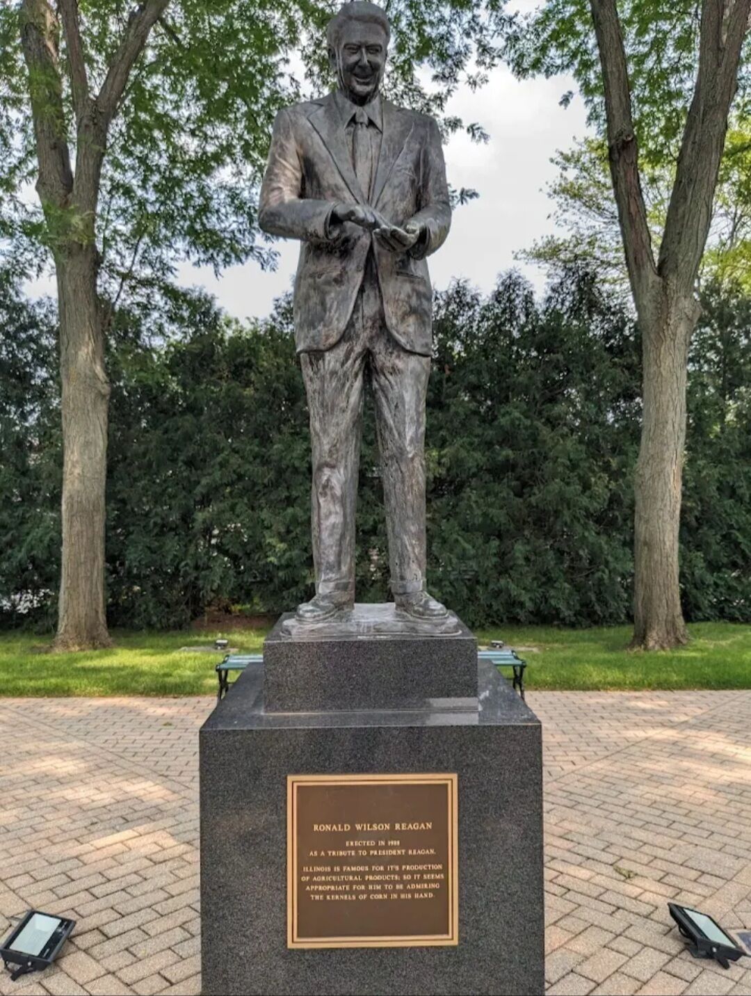 Una statua di Ronald Wilson Reagan su un piedistallo con una targa.