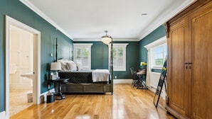A bedroom with a bed, bedside table, lamp, and a large wooden wardrobe. - Mayville Union House (Bethel)