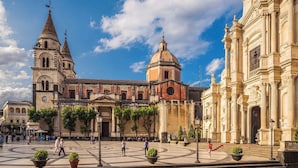 A historic plaza with a prominent church featuring a bell tower and a dome, surrounded by classical architecture and open spaces for visitors. - Charming Historic Home with Garden Views in the Heart of Acireale (Acireale)