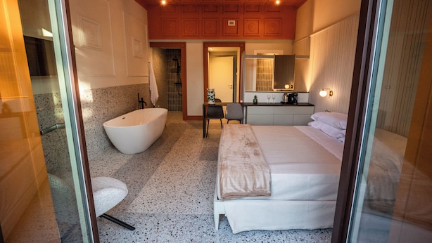 A modern bathroom with a freestanding bathtub, a vanity with a mirror, and a shower area. - Charming Historic Home with Garden Views in the Heart of Acireale (Acireale)