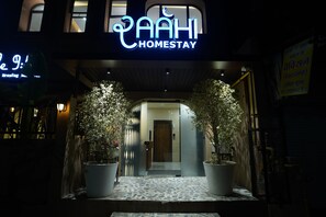 A hotel entrance with a neon sign reading "AAHI HOMESTAY" and a signboard in a foreign language. - RAAHI HOMESTAY (Ujjain)
