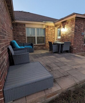 A patio with wicker furniture, a table, and a window. - Secluded Water Front (Sanger)