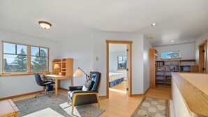 A spacious room with a desk, two chairs, a bed, and a bookshelf. - Charming Two Story Home with Hot Tub (Driggs)