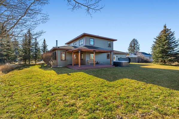 A two-story house with a covered porch, a hot tub, and a well-maintained lawn. - Charming Two Story Home with Hot Tub (Driggs)