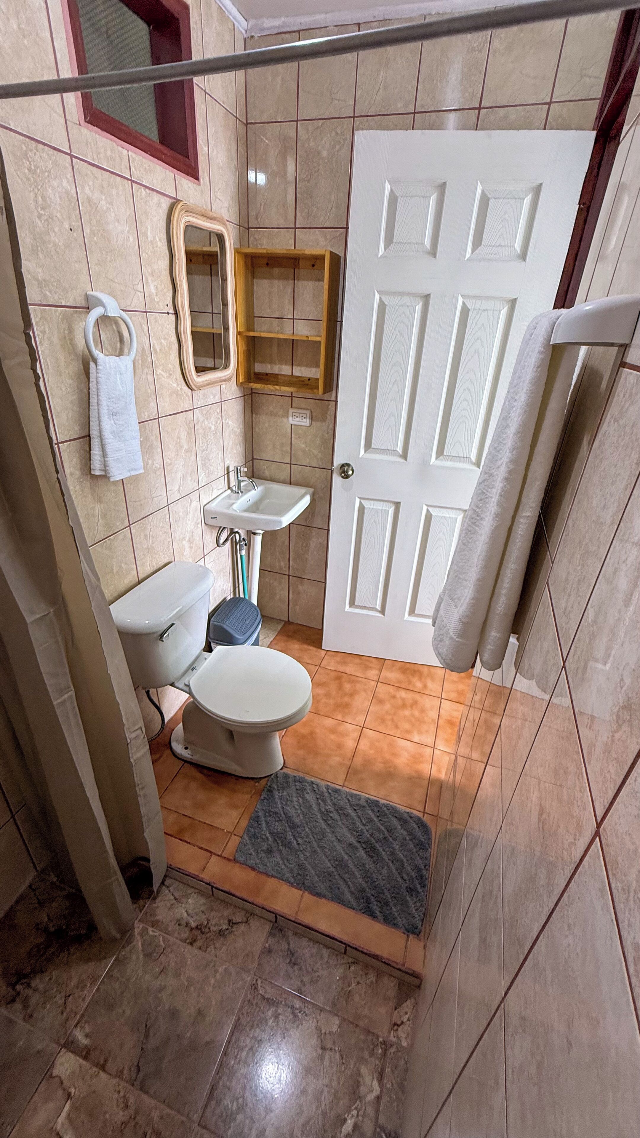 A bathroom with a toilet, sink, and shower area.