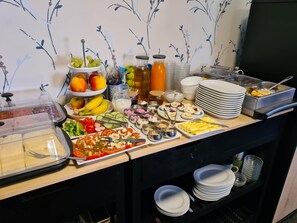 A buffet with various food items and condiments. - Hotel Pension Friesenruh (Esens)