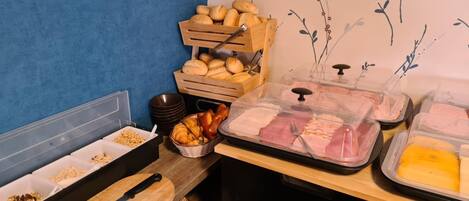 Un bufé de desayuno con diferentes alimentos y utensilios.