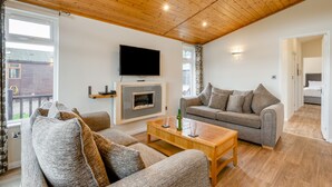 A living room with a fireplace, sofa, television, and wooden ceiling. - Field View 2 bed (S)- Spruce - sleeps 6 guests  in 2 bedrooms (Eye)