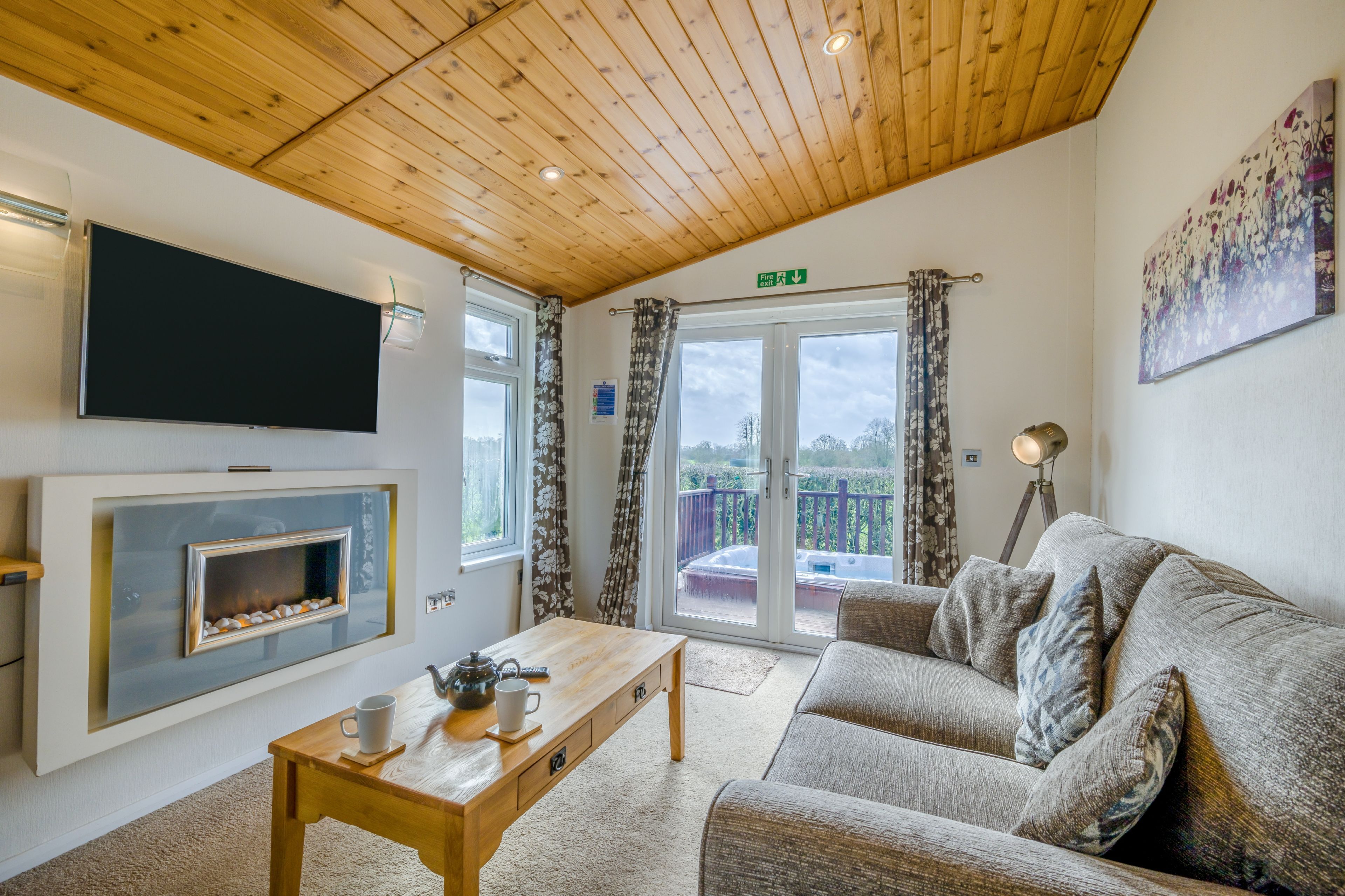 Una sala de estar acogedora con chimenea, sofá, mesa de centro y televisor de pantalla plana.