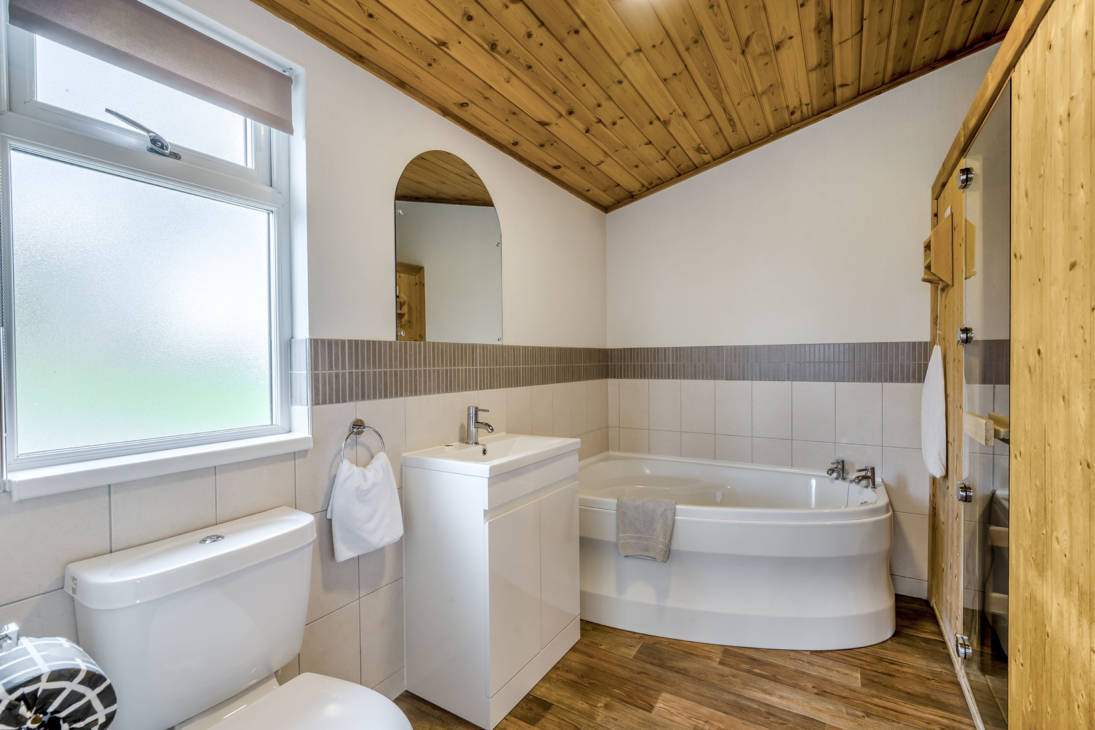 Et moderne badeværelse med toilet, håndvask og badekar.