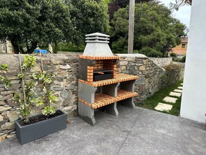 Eine Steinsäule mit einem Grill aus Ziegelsteinen.