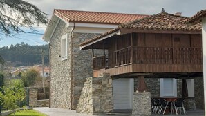 A stone house with a tiled roof, a balcony, and a patio with chairs. - La Quintana de Pola (Brand-new luxury country retreat in Cudillero) (Cudillero)
