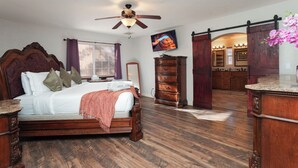 A bedroom with a wooden bed, a dresser, a vanity, and a ceiling fan. - Pool Days, Play Days, Paws Welcome (Cottonwood)