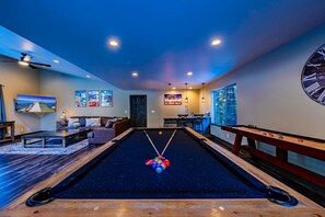 A pool table in a room with a sofa, a television, and artwork on the walls. - Luxury Slopeside Ski Haus | Hot Tub + Sauna | 12P (South Lake Tahoe)