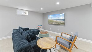A modern living room with a sectional sofa, a wooden coffee table, and a lounge chair.