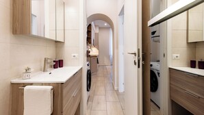 Une salle de bain moderne avec un grand miroir, un lavabo et un porte-serviettes.