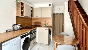 A compact kitchen with a washing machine, a coffee maker, and a sink. - Casa Romana, the Southern Style Cottage (Balaruc-les-Bains)