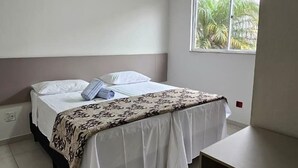 A room with a bed, a desk, and a chair.