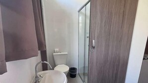 A bathroom with a sink, toilet, and shower.