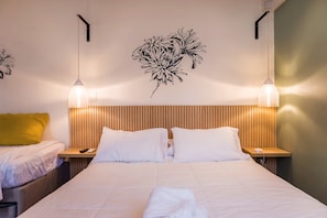 Ein Hotelzimmer mit einem Bett, zwei Nachttischen, einer Wandleuchte und einer Wanddekoration.
