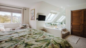 Una camera da letto con un letto, una scrivania, una finestra, una ventola a soffitto e una porta in legno.