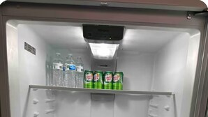 Un refrigerador vacío con dispensador de agua y refrescos, un cajón congelador y un compartimento principal.