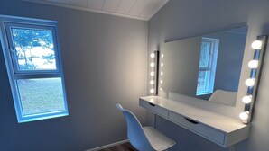 A modern bathroom with a vanity, mirror, and lights. - Kot apartment (Hvolsvöllur)