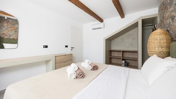 Habitación de hotel con cama, escritorio, armario y cesta colgante.