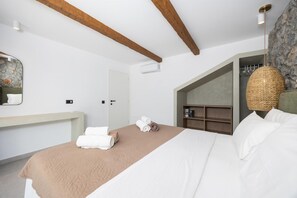 A bedroom with a bed, a wooden headboard, a stone wall, a wooden shelf, and a hanging lamp. - Villa Celestia - Two Bedroom Villa, Sleeps 4 (Afandou)