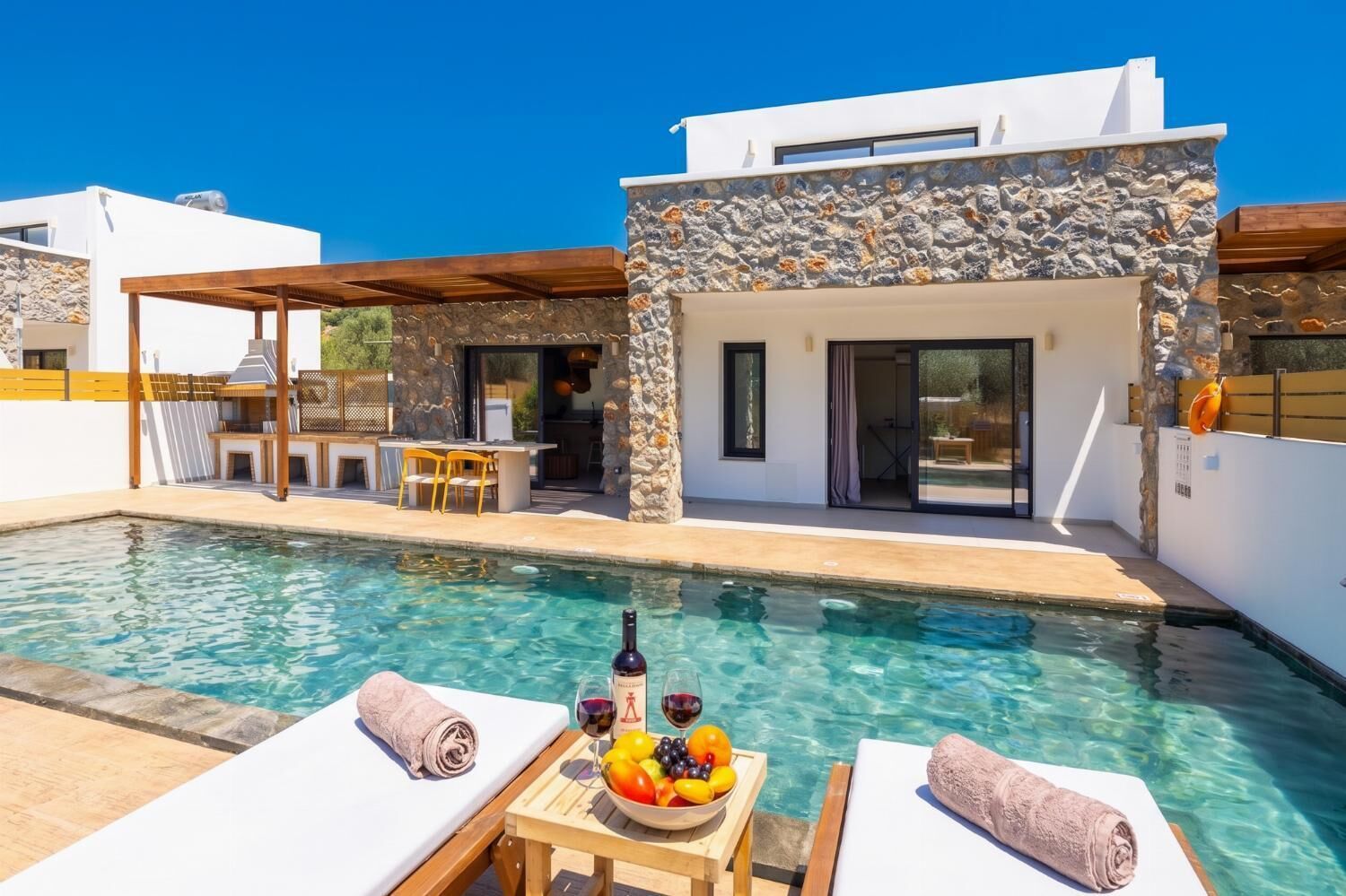 Uma villa moderna com piscina, área de estar ao ar livre e fachada de pedra.